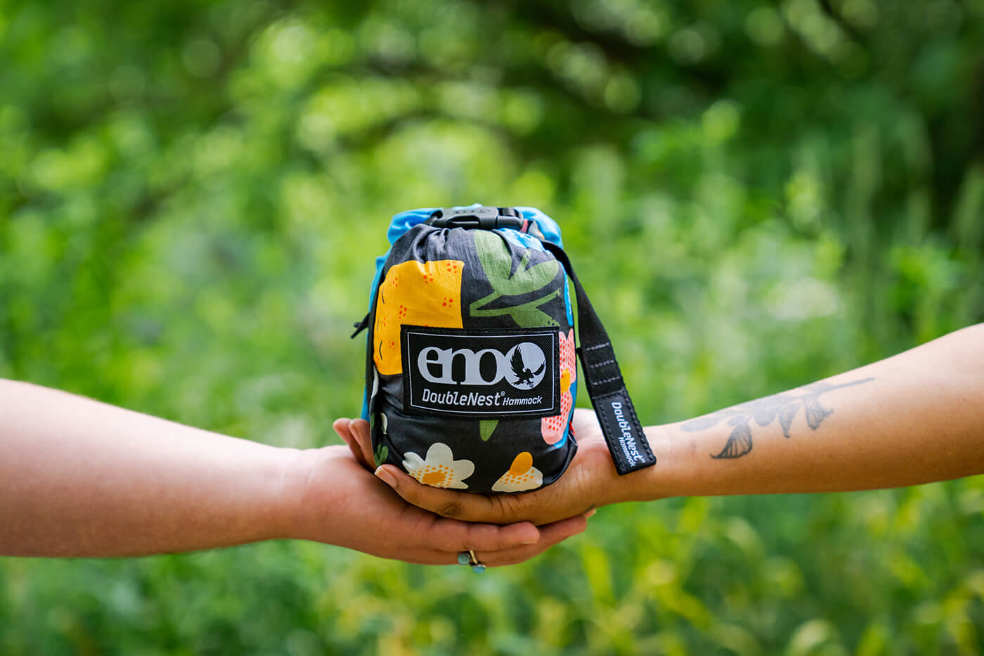 Two arms holding ENO Brave Trails DoubleNest Hammock Stuff Sack