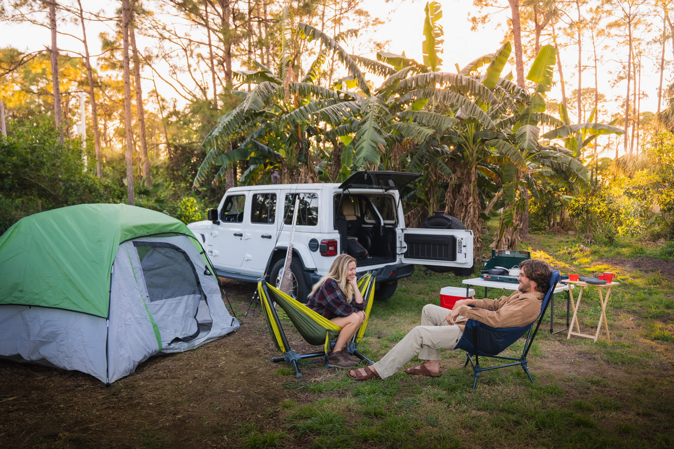 A man and woman camping and sitting in ENO gear