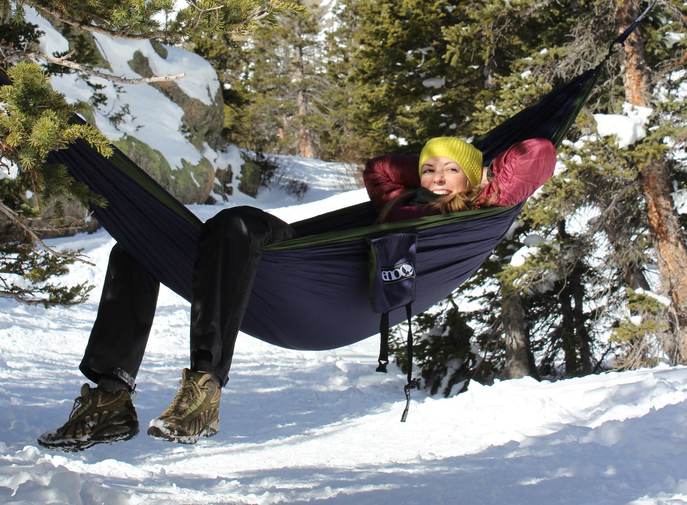 woman relaxing in an ENO hammock in the snowy Rocky Mountain National Park forest