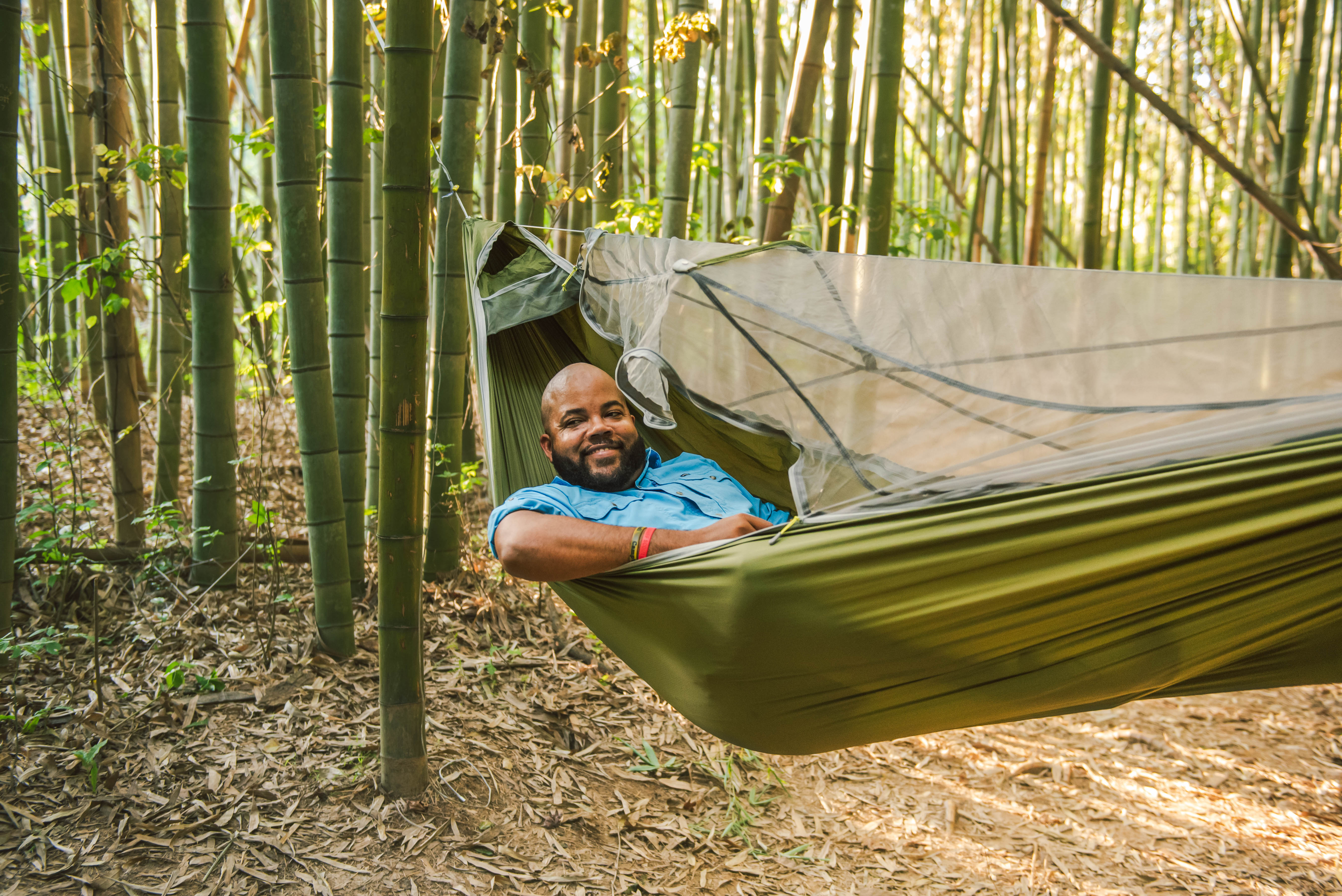 Nick Brooks smiles in an ENO hammock in a bamboo forest