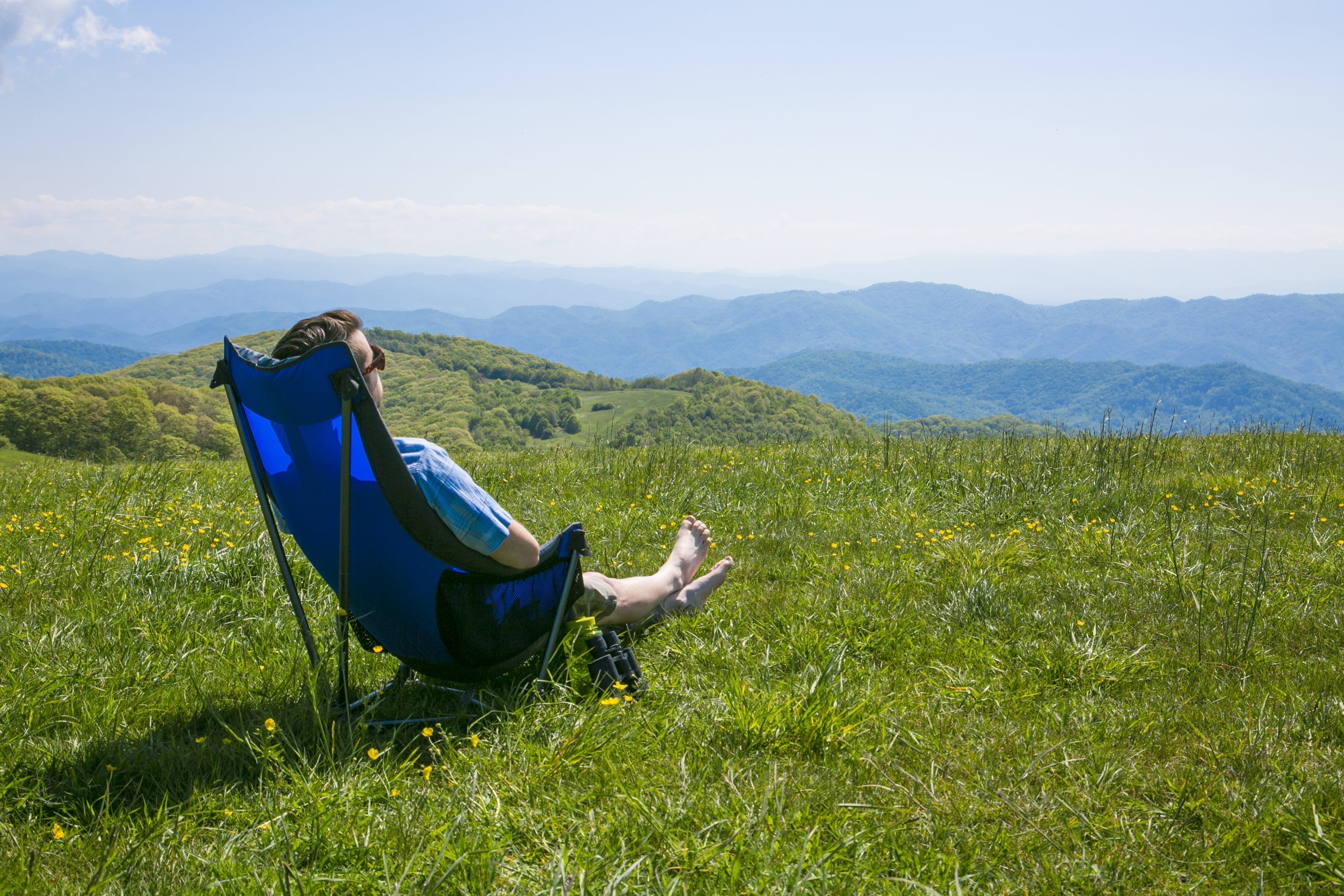 A man sitting in an ENO Lounger DL Chair looking at mountain ranges