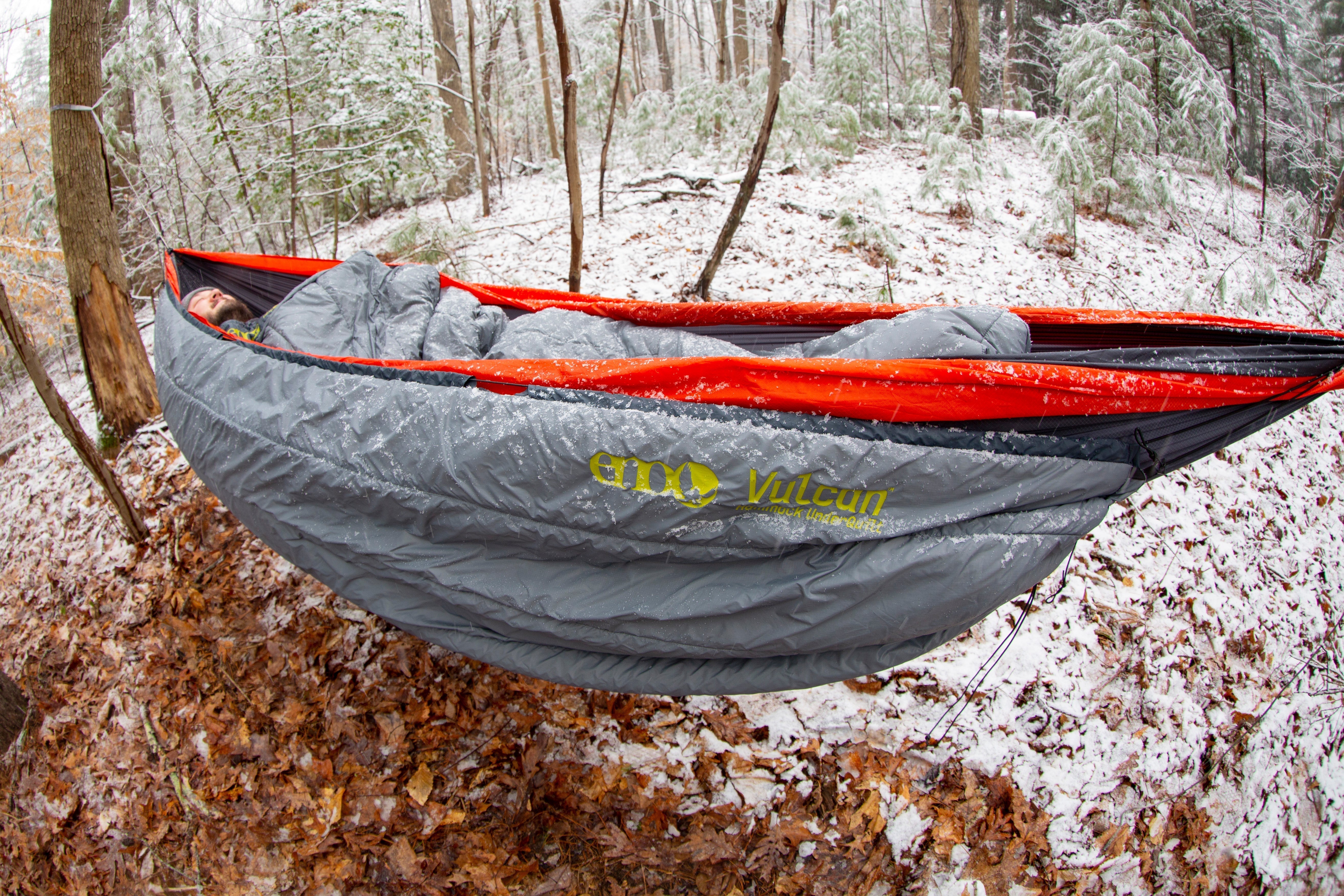 A man sleeping in an ENO hammock in show with an ENO top and under quilt