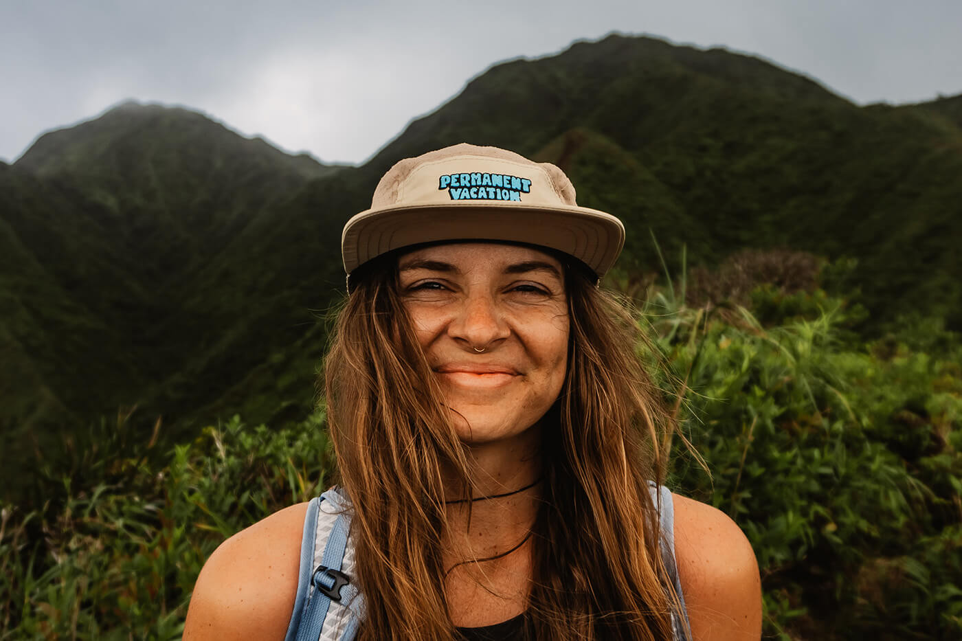 Haleigh Hendrickson smiles at camera with lush green mountains behind her
