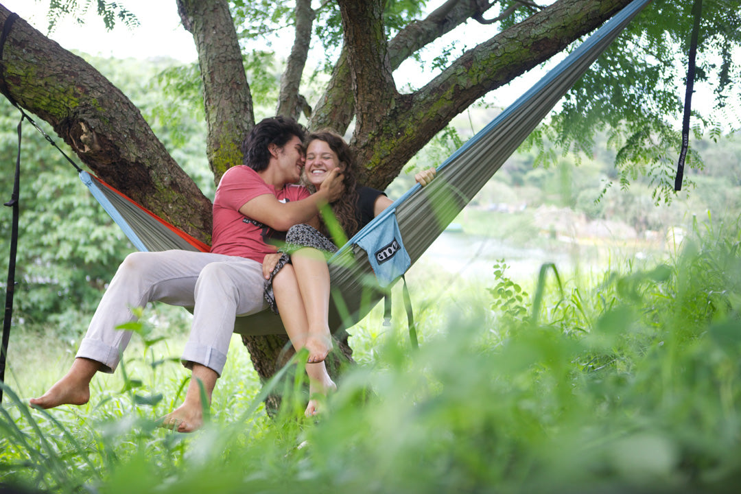 Two people laughing in an ENO hammock