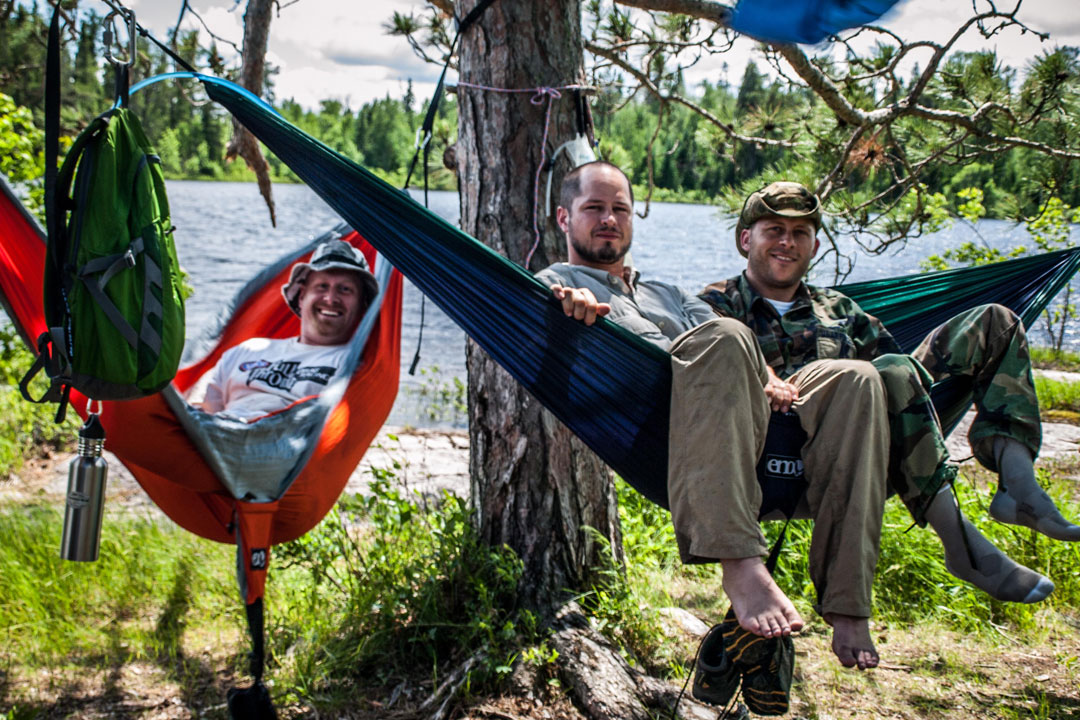 3 friends hammocking in 2 ENO hammocks with a lake behind them