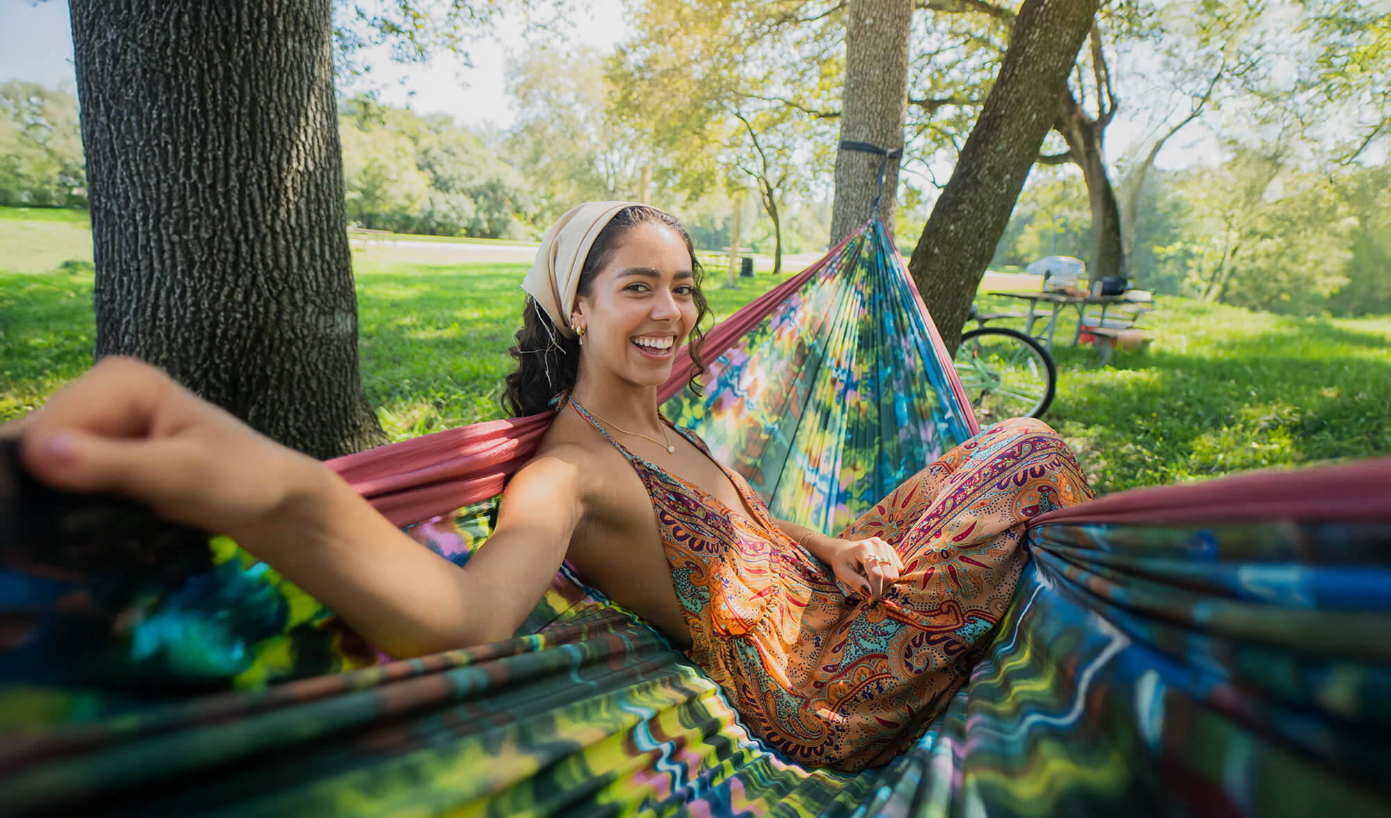 Woman relaxing in the ENO DoubleNest Hammock Print Tie-Dye Shibori in a park