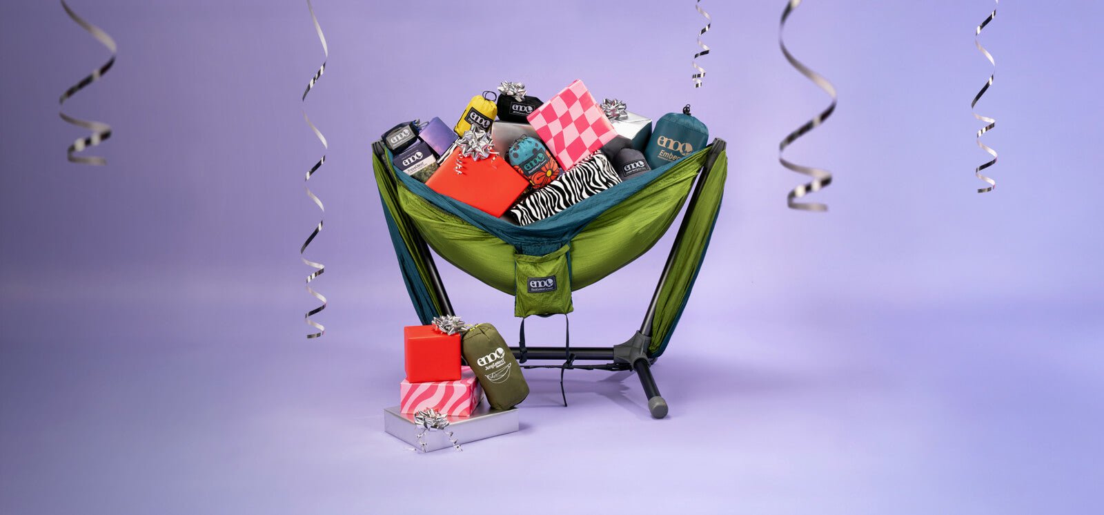 DoubleNest Hammock setup on a ParkLite Hammock Chair Stand with various gifts and items on a purple background