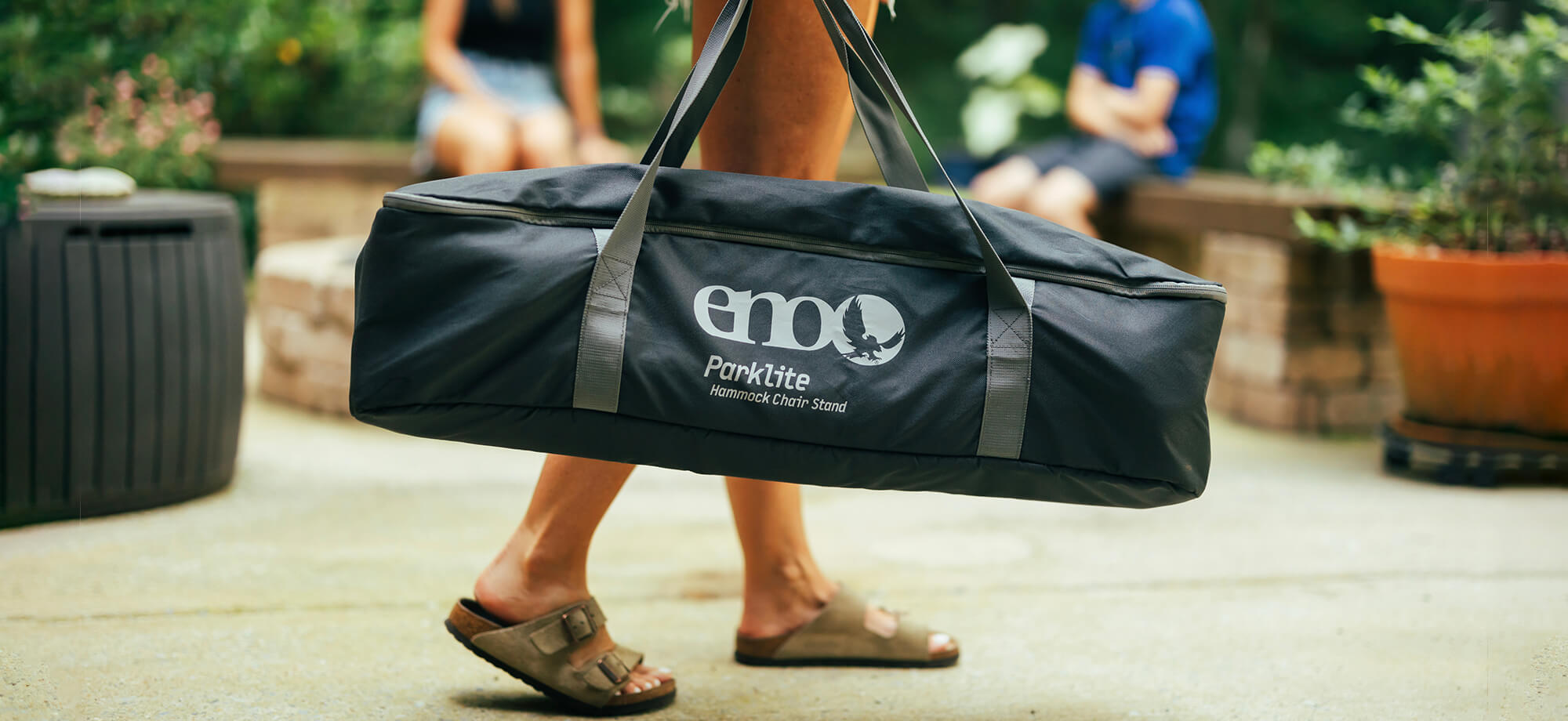 Close up image of the ENO Parklite Hammock Chair Stand in custom carrying case being carried on porch.