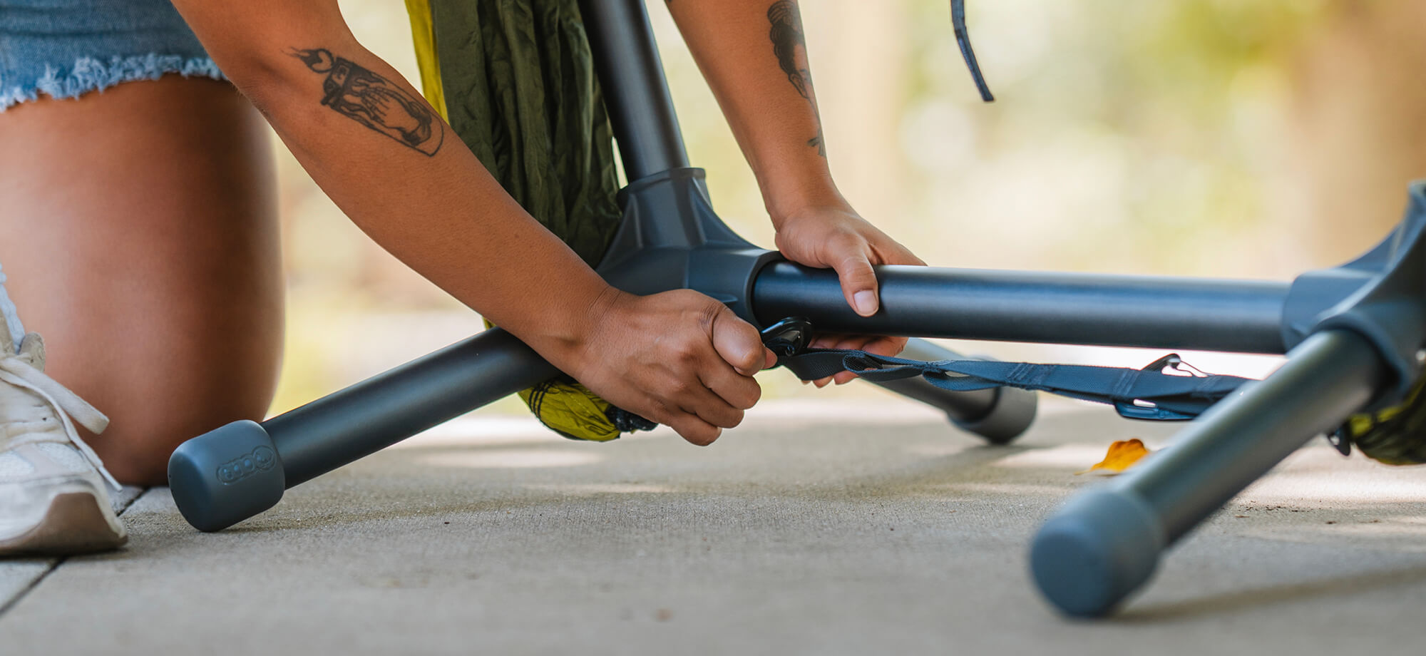 Close up image of person clipping a hammock carabiner onto the straps of the ENO Parklite Hammock Chair Stand.