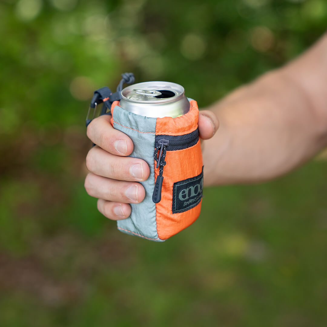 Person holding a ENO BevNest with can in an outdoor setting.