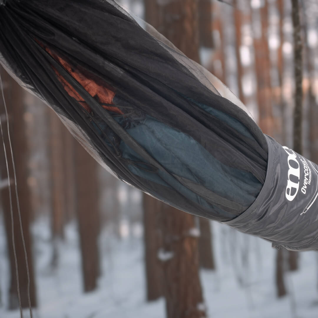 Close up of the Overcast Hammock Cover going over the hammock, bug net, and underquild in a snowy forest setting