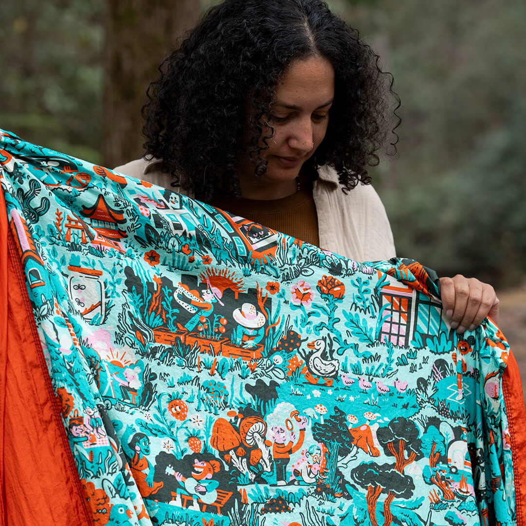 Woman holding a colorful patterned ENO Giving Back Hammock