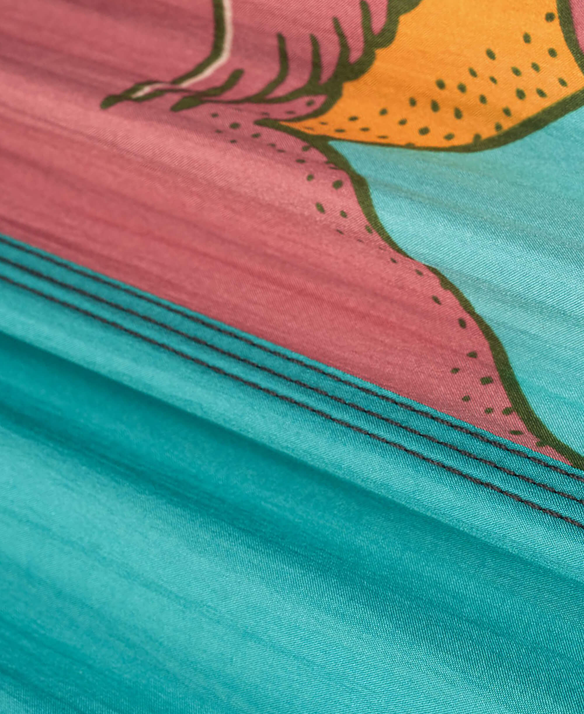 Close-up of colorful fabric with pink, orange, and teal patterns.