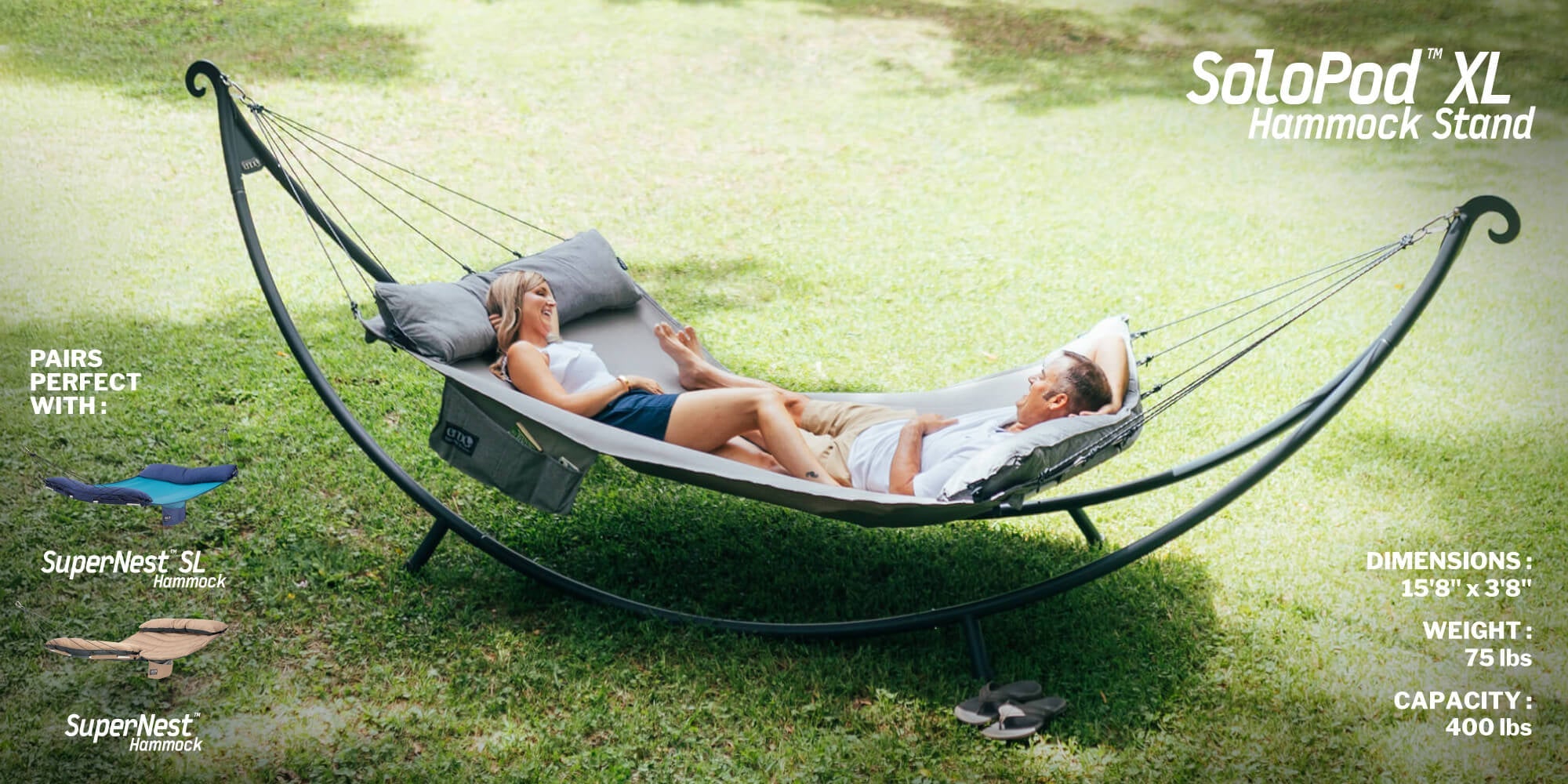 Two people relaxing in a SuperNest Hammock connected to a SoloPod XL Hammock Stand in grassy setting.