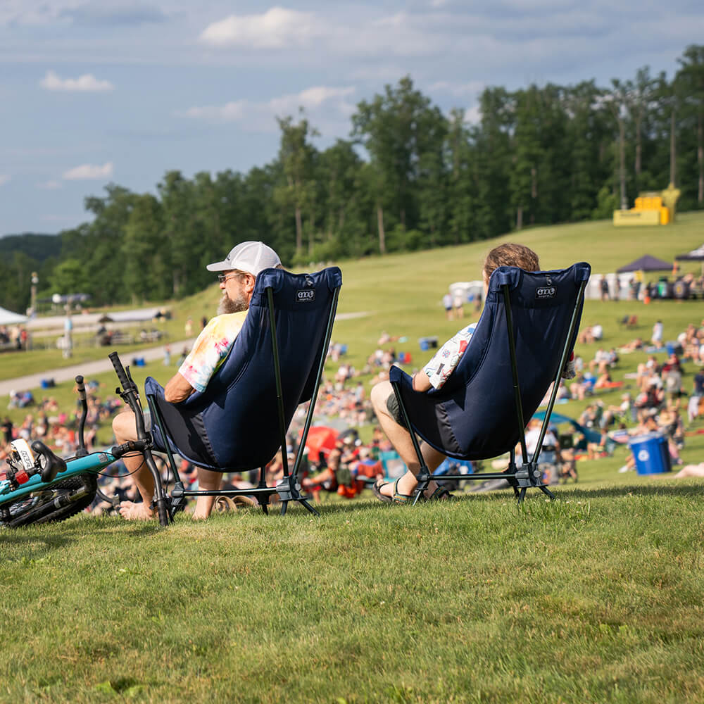 Two people sit side-by-side at a music event in Lounger DL Chairs.