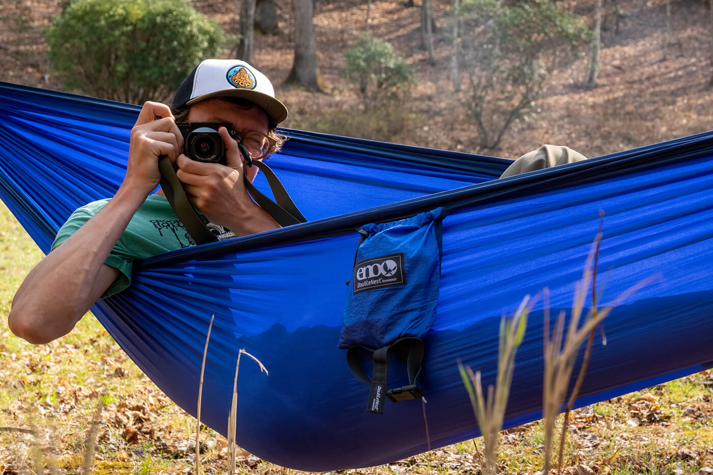 Person taking a photo from a blue hammock in a natural setting