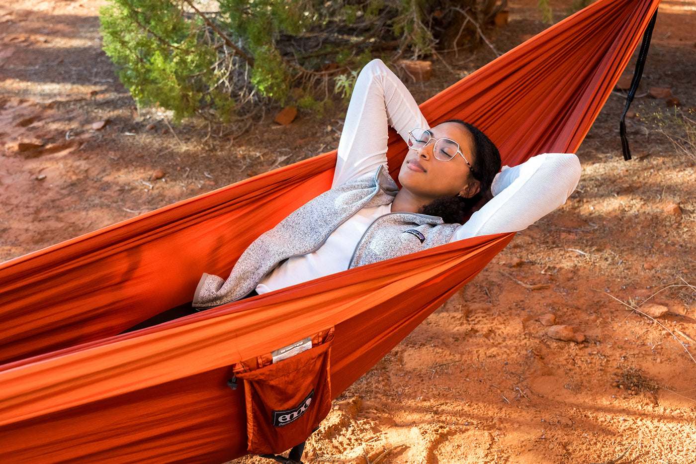 A woman relaxes in the desert in her ENO DoubleNest Hammock