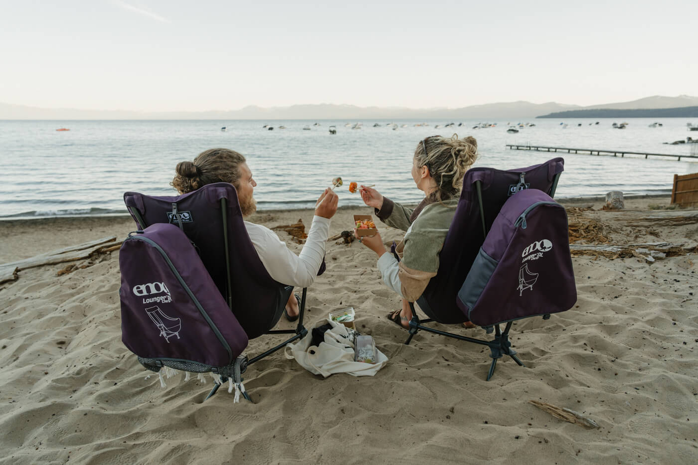 Two people eating at the beach in ENO Lounger DL Chairs