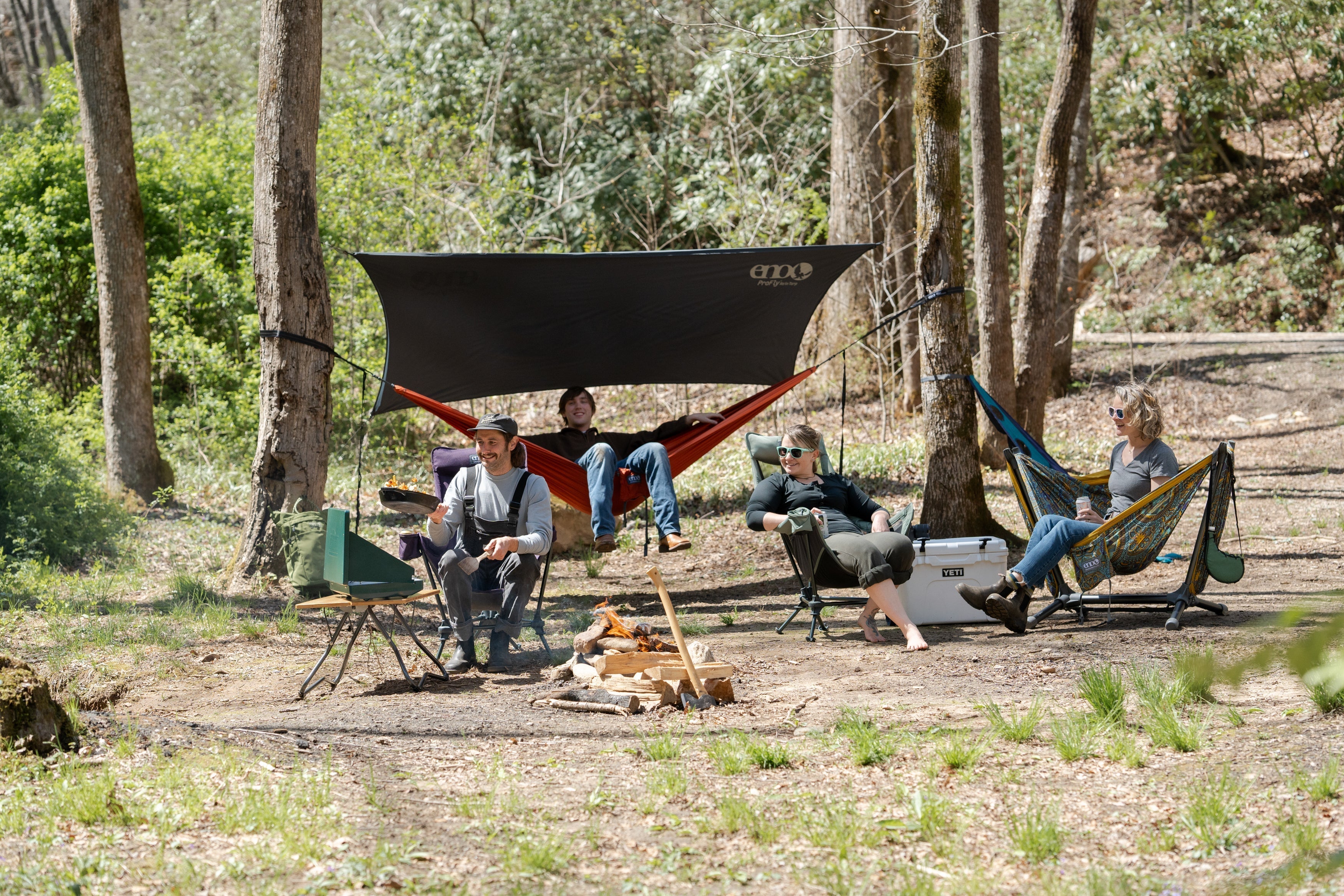 A group of people camping with various ENO gear and cooking 