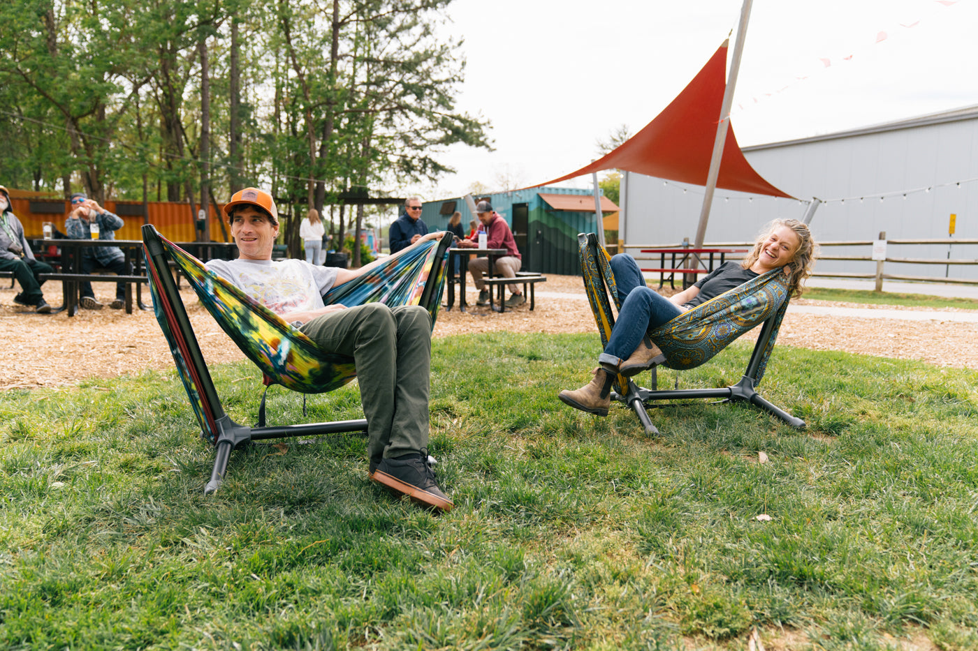 Two people sit in Parklite Hammock Chair Stands at Highland Brewing in Asheville, NC