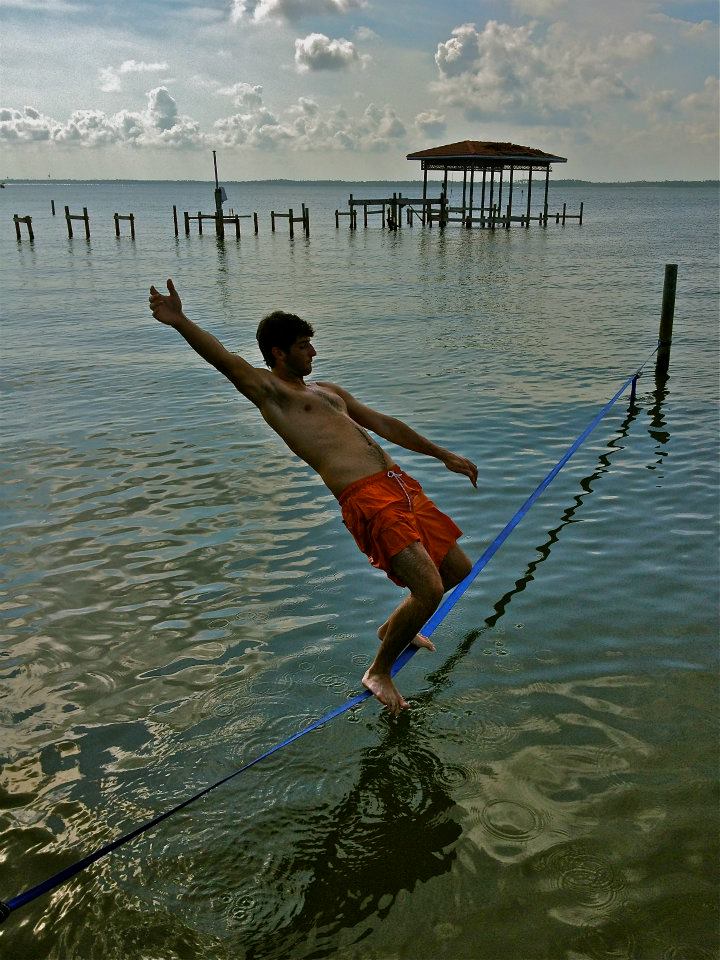 Man slacklining across water