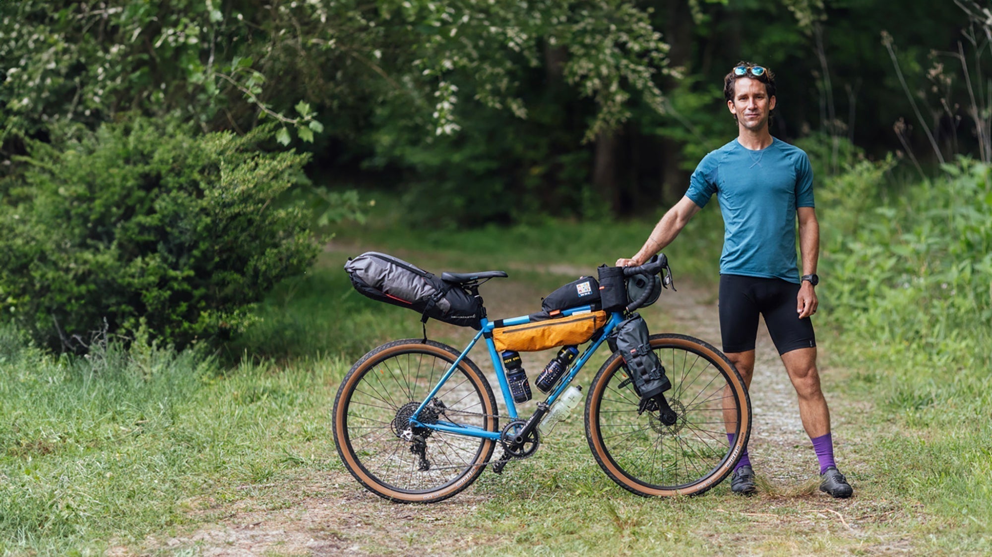 A man poses for a portrait with his bike before racing the Wilson's Ramble