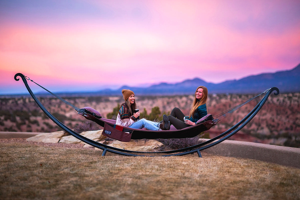 two woman hanging in hammock setup in a hammock stand