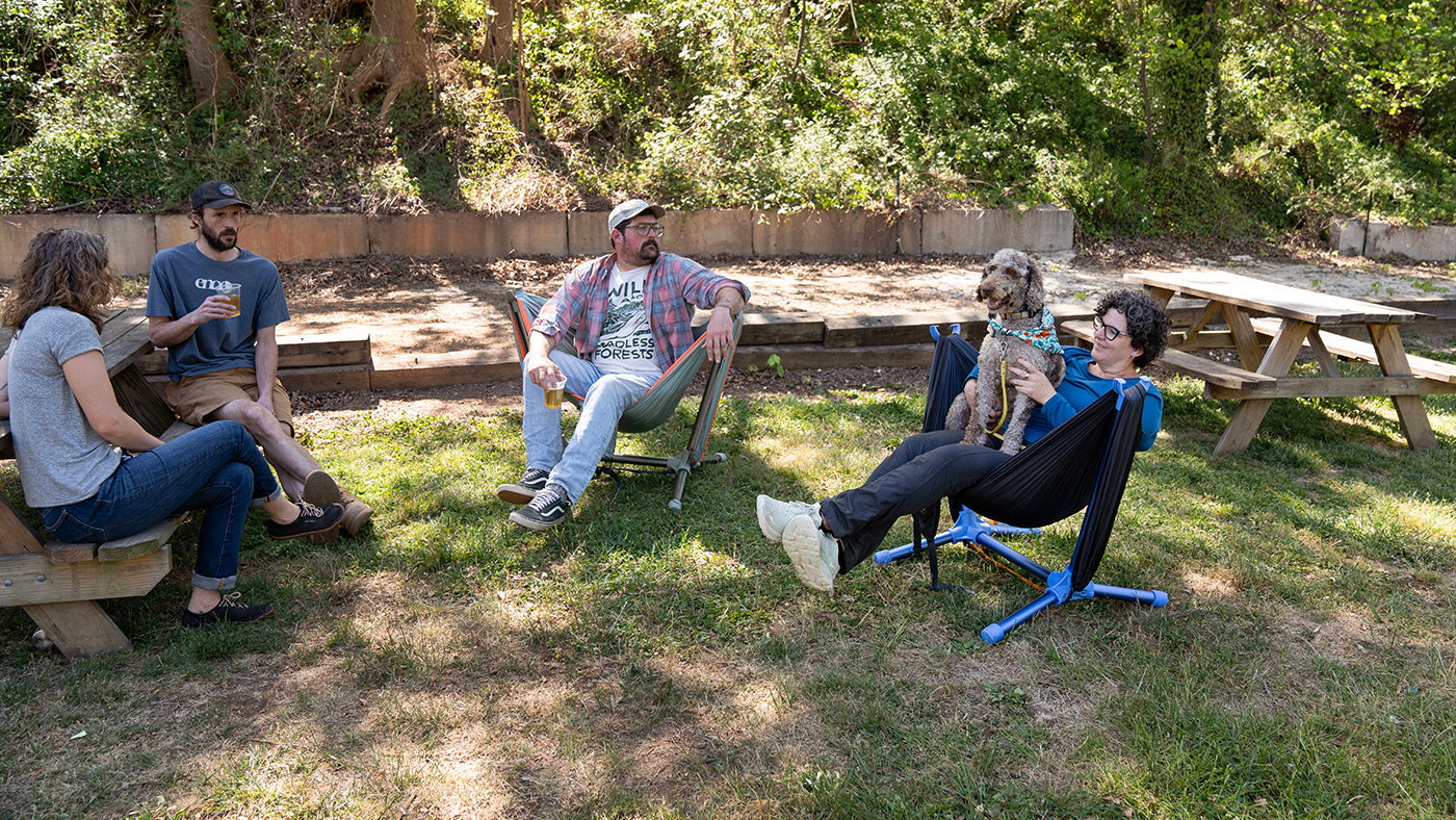 A group of friends hang out together at a brewery while sitting in ENO hammock chairs
