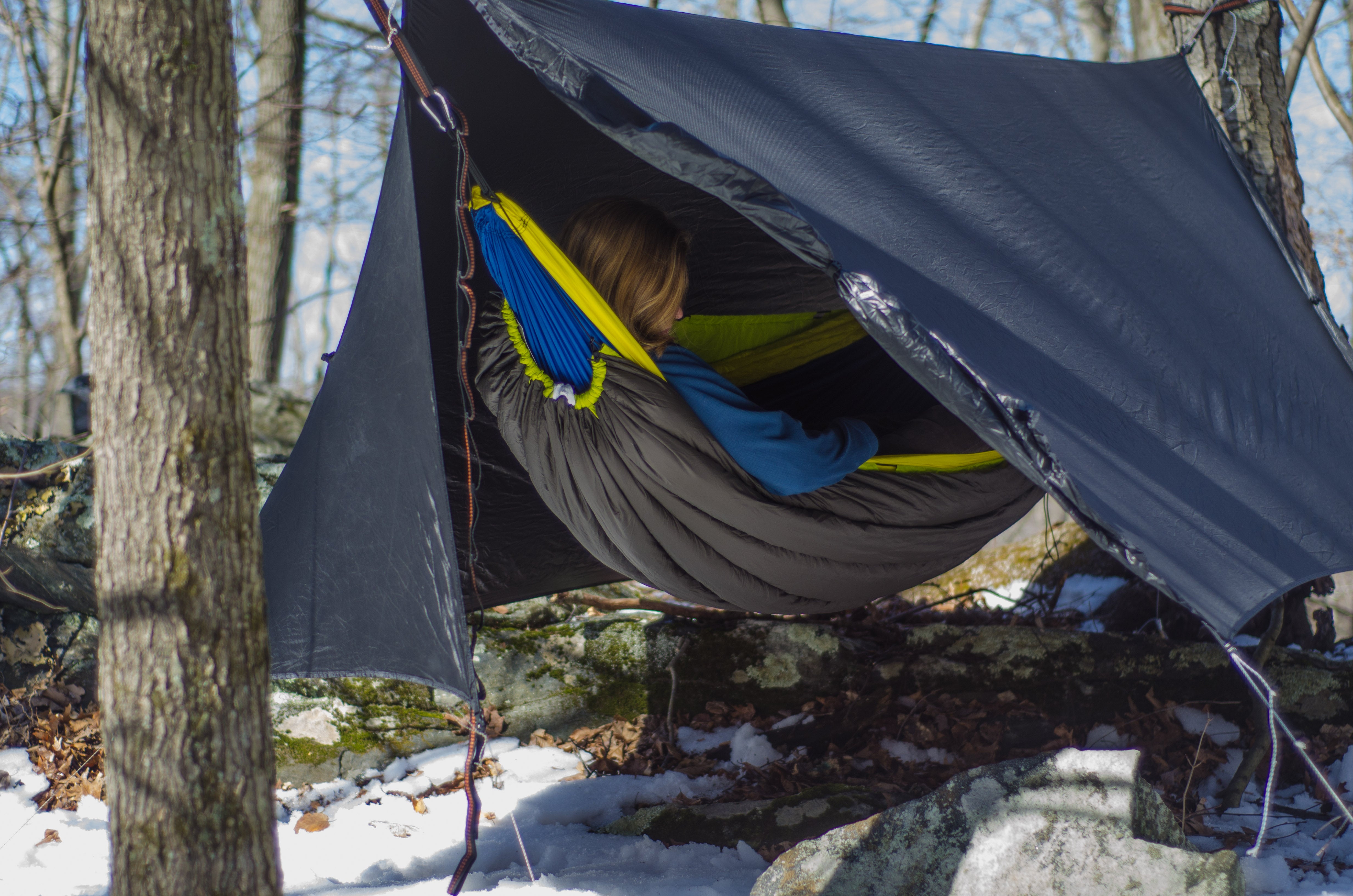 person relaxing in a hammock under the HouseFly rain fly