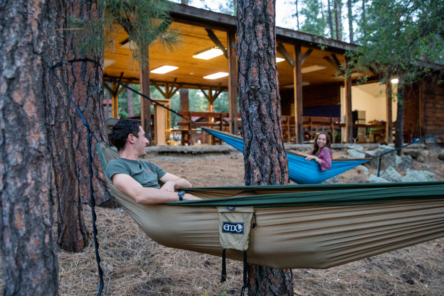 people hanging in ENO hammocks in the woods