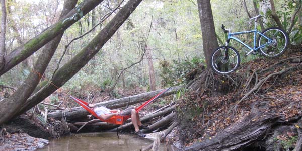 man relaxing in a hammock after mountain bike orienteering