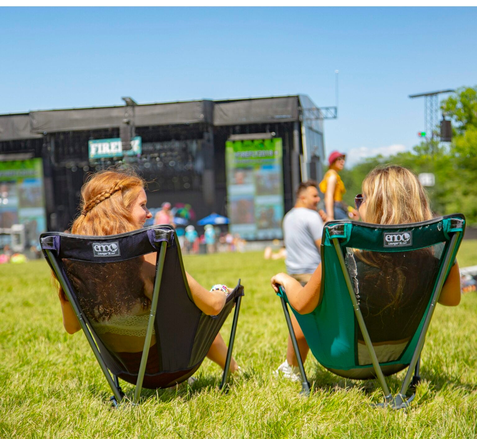 two friends sitting in ENO camp chairs at a festival