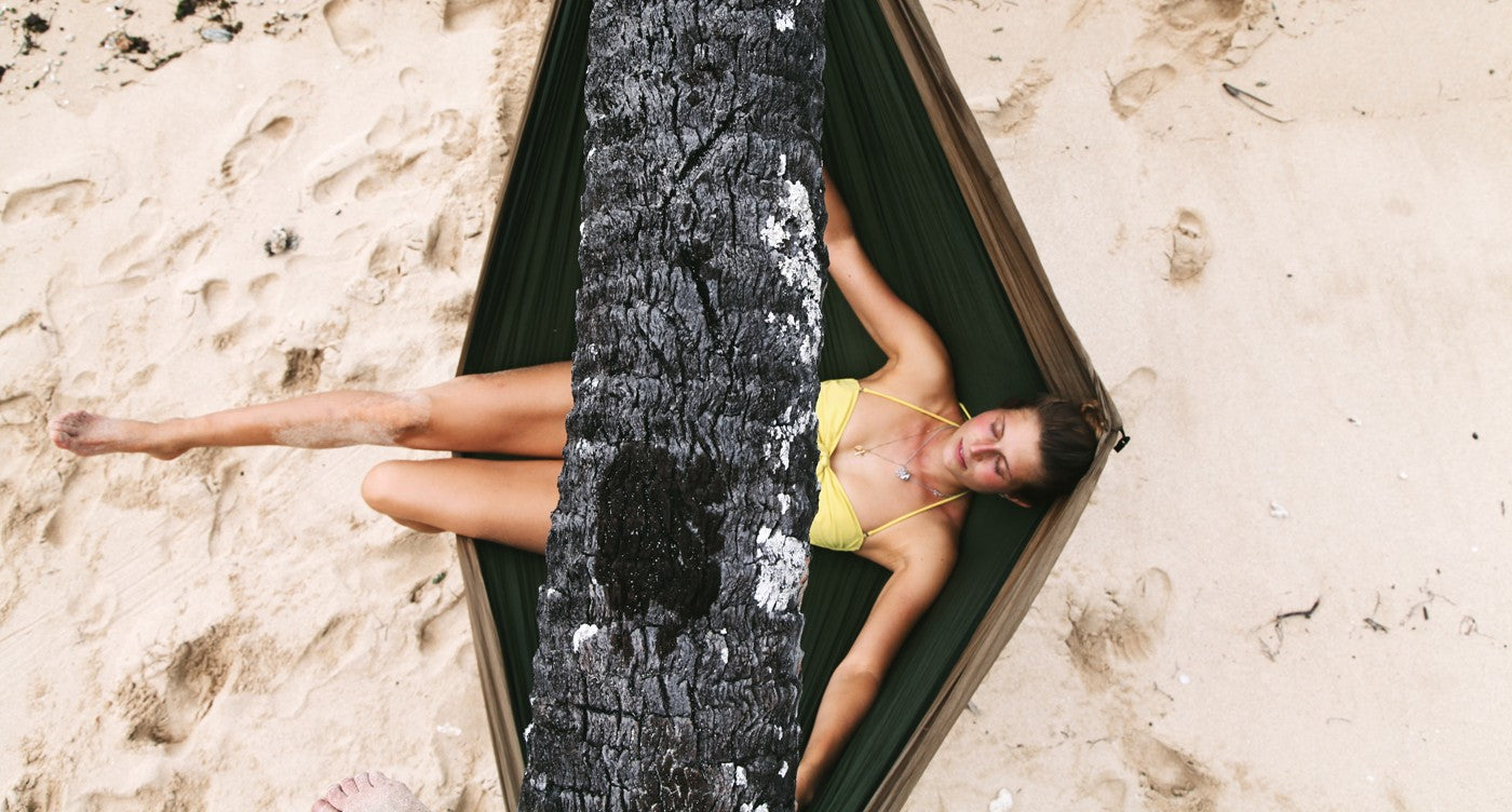 woman relaxing on a hammock on the beach