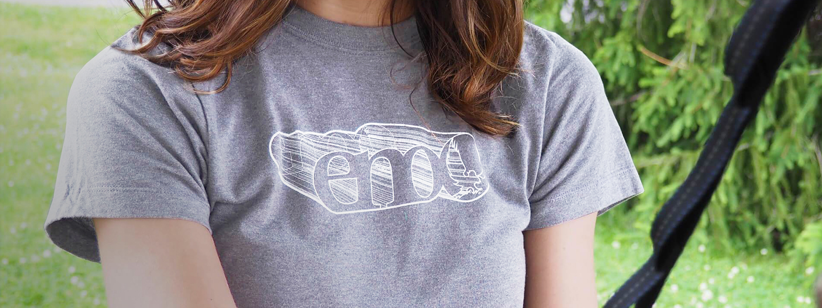 A woman in a ENO tee shirt holding a hammock strap.