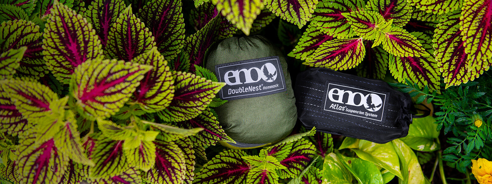 ENO DoubleNest Hammock and Atlas Hammock Straps laying in lush leaves.