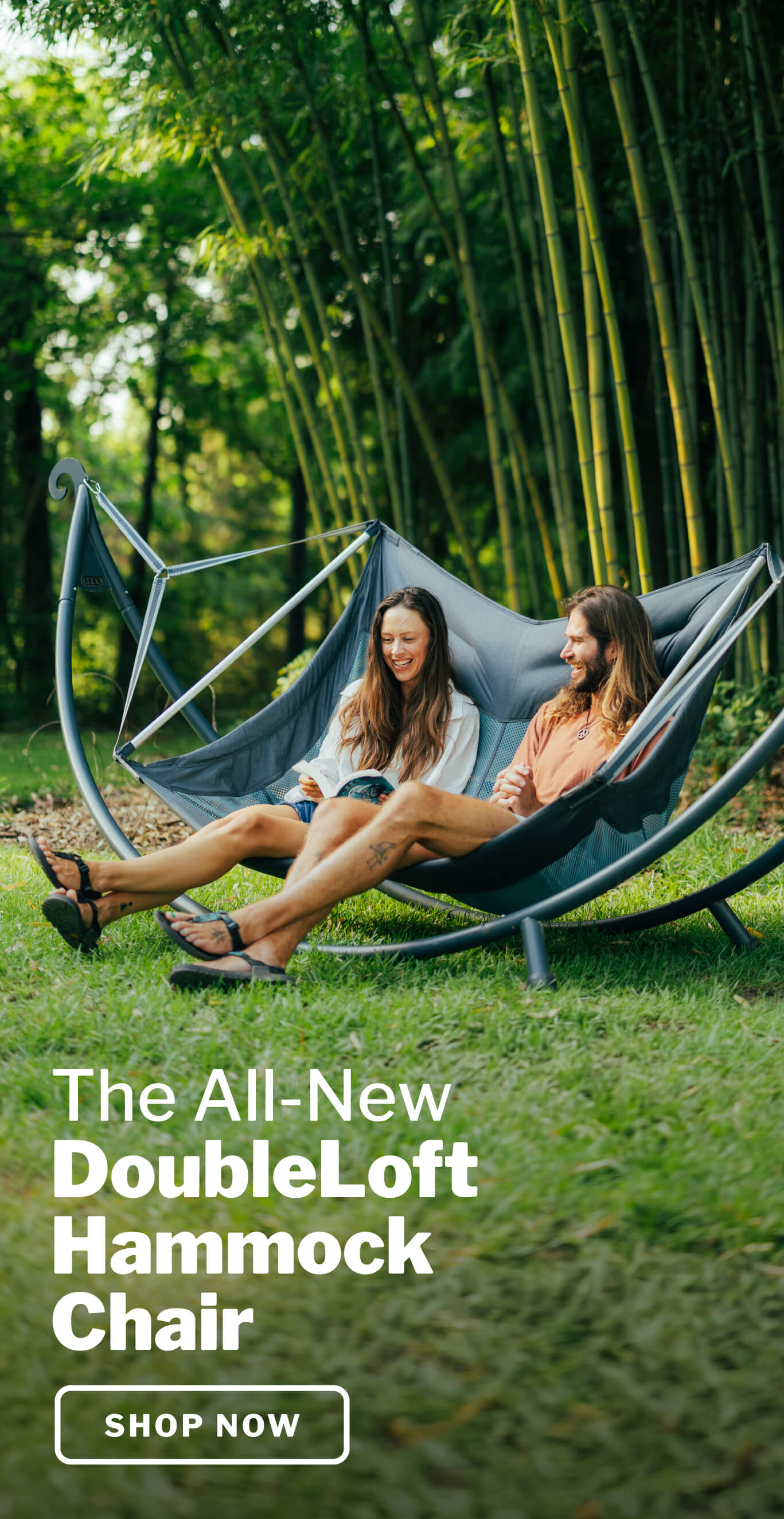 Two people sitting in a DoubleLoft Hammock Chair in a natural setting with bamboo.