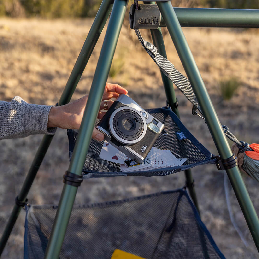 Person grabbing a camera out of the top shelf of the Nomad Gear Loft.