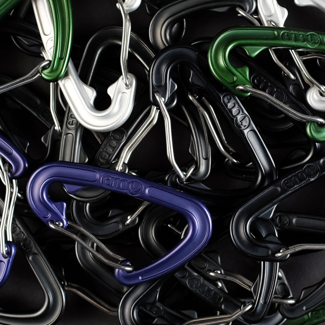 ENO hammock carabiners piled on top of one another in silver, blue, green, and black colors. 