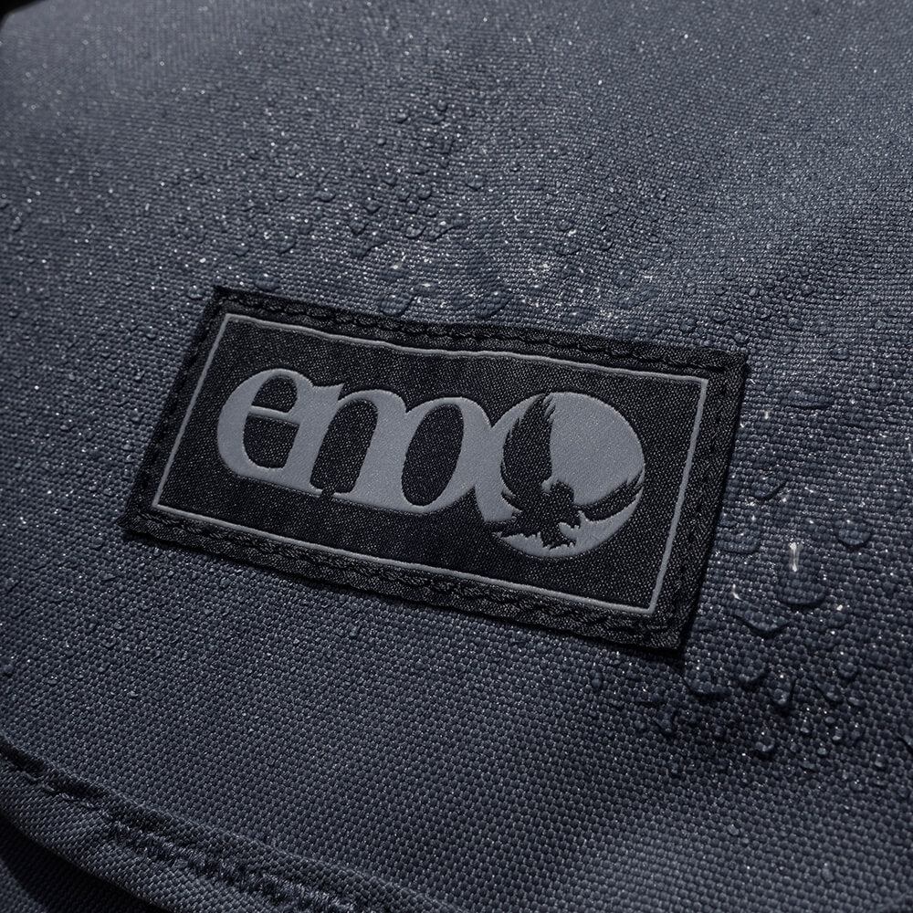 Close-up detail of black ENO pack material with water droplets beading on the fabric. 