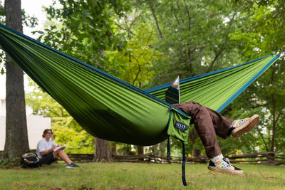 College student working on laptop in ENO DoubleNest Hammock + Atlas Straps Bundle in Cedar Marine