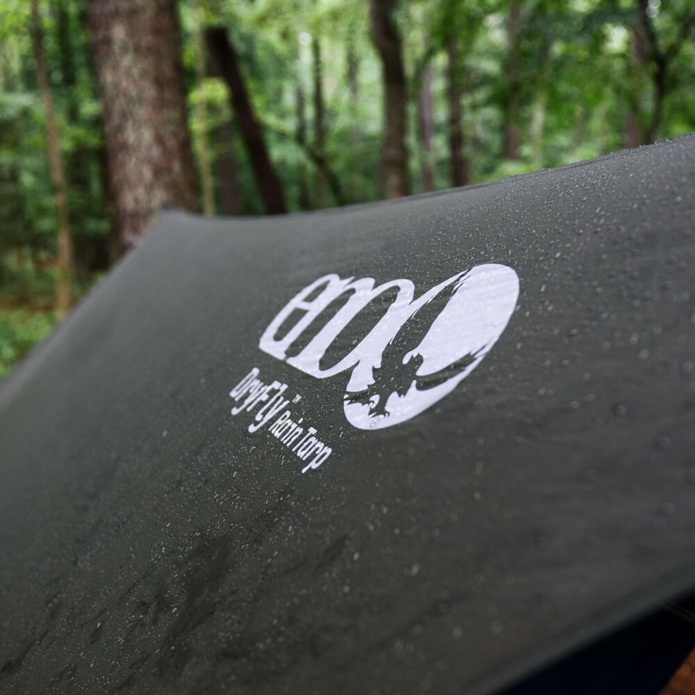 Detail of water droplets on ENO rain tarp material in a lush wooded environment.